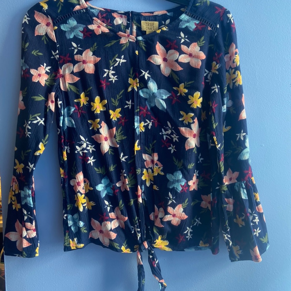 A navy blue with flowers, and its a blouse and has an extra button for the back